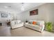Spacious living room with tile flooring, white sofas, and a view of the dining area at 17523 Promenade Dr, Clermont, FL 34711