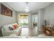 Bright living room with tile floors, white sofas, a chandelier, and sliding glass door at 17523 Promenade Dr, Clermont, FL 34711
