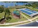 Aerial view of a playground and tennis court next to lake at 17523 Promenade Dr, Clermont, FL 34711
