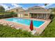 Community pool with lounge chairs, tables, and a relaxing umbrella at 17523 Promenade Dr, Clermont, FL 34711