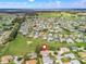 Aerial view of a residential community with landscaped lawns, mature trees, and golf course at 17652 Se 120Th Ter, Summerfield, FL 34491