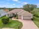Well-maintained home with a brick driveway, lush lawn, and mature landscaping at 17652 Se 120Th Ter, Summerfield, FL 34491