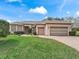 Lovely home with a manicured lawn, brick driveway, and an attached two-car garage at 17652 Se 120Th Ter, Summerfield, FL 34491