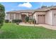 Well-maintained house with brick driveway, lush greenery, and a two-car garage at 17652 Se 120Th Ter, Summerfield, FL 34491