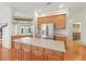 Kitchen island featuring extra cabinet space and stainless steel appliances, including a refrigerator at 17652 Se 120Th Ter, Summerfield, FL 34491