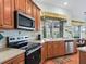 Well-equipped kitchen featuring stainless appliances, light countertops, and wood-finished cabinets at 17652 Se 120Th Ter, Summerfield, FL 34491