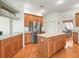 Bright kitchen with wood cabinets, stainless steel fridge, an island, and view to the breakfast room at 17652 Se 120Th Ter, Summerfield, FL 34491