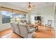 Living room with large windows, wood floors, ceiling fan, and comfortable seating at 17652 Se 120Th Ter, Summerfield, FL 34491