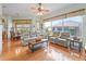 Living room with large windows, wood floors, ceiling fan, and comfortable seating at 17652 Se 120Th Ter, Summerfield, FL 34491