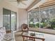 Enclosed sunroom featuring wicker furniture, ceiling fan, and sliding glass doors to the exterior at 17652 Se 120Th Ter, Summerfield, FL 34491