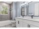 Modern bathroom with double vanity, gray tile, and black fixtures at 18315 Dells Cv, Groveland, FL 34736