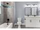 Modern bathroom with double vanity, gray tile, and black fixtures at 18315 Dells Cv, Groveland, FL 34736