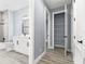 Modern bathroom with white vanity, gray tile, and a large mirror at 18315 Dells Cv, Groveland, FL 34736