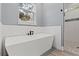 Modern bathroom with soaking tub and walk-in shower at 18315 Dells Cv, Groveland, FL 34736