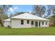 Home's rear elevation showcases patio and metal roof at 18315 Dells Cv, Groveland, FL 34736
