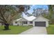 Modern farmhouse exterior with metal roof and dark gray garage door at 18315 Dells Cv, Groveland, FL 34736