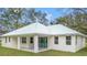 Home's rear elevation showcases patio and metal roof at 18315 Dells Cv, Groveland, FL 34736