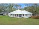 Home's rear elevation showcases patio and metal roof at 18315 Dells Cv, Groveland, FL 34736