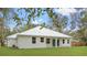 White house with metal roof, covered patio, and grassy backyard at 18315 Dells Cv, Groveland, FL 34736