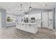 Modern kitchen with white cabinets, large island, and gray walls at 18315 Dells Cv, Groveland, FL 34736