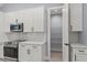 Modern kitchen with white cabinets, pantry, and stainless steel appliances at 18315 Dells Cv, Groveland, FL 34736