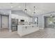 Modern kitchen with white cabinets, large island, and gray walls at 18315 Dells Cv, Groveland, FL 34736