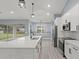 Modern kitchen with white cabinets, large island, and stainless steel appliances at 18315 Dells Cv, Groveland, FL 34736