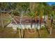 Aerial view of a charming home with a brown roof surrounded by lush greenery and palm trees at 18415 County Road 33, Groveland, FL 34736