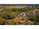Aerial view of the home and surrounding properties in a green, wooded area at 18415 County Road 33, Groveland, FL 34736