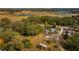 This aerial view shows a home with a spacious yard surrounded by lush green trees and open fields at 18415 County Road 33, Groveland, FL 34736