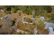 This aerial view shows a home with a brown roof, set among palm trees in a large, wooded area at 18415 County Road 33, Groveland, FL 34736