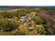 This aerial view shows a home with a spacious yard surrounded by lush green trees and open fields at 18415 County Road 33, Groveland, FL 34736