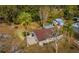 Aerial view of the home featuring a patio set and a surrounding canopy of trees at 18415 County Road 33, Groveland, FL 34736