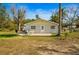 Backyard with an open patio and a well-maintained lawn, perfect for outdoor entertaining at 18415 County Road 33, Groveland, FL 34736