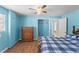 A bedroom features blue walls, wood-look floors, and a ceiling fan at 18415 County Road 33, Groveland, FL 34736