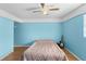 Bedroom featuring blue painted walls and wood look flooring at 18415 County Road 33, Groveland, FL 34736