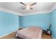 Light blue bedroom featuring a ceiling fan, guitar, and wooden floors at 18415 County Road 33, Groveland, FL 34736