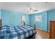 Bright bedroom features blue walls, ceiling fan, and wood-look flooring at 18415 County Road 33, Groveland, FL 34736