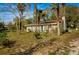 Charming home featuring a light yellow exterior, brown roof, and mature trees on a spacious lot at 18415 County Road 33, Groveland, FL 34736