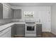 Modern kitchen featuring white appliances, gray cabinetry, and stylish countertops at 18415 County Road 33, Groveland, FL 34736