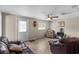 Cozy living room with a ceiling fan, wood-look flooring, and comfortable leather seating at 18415 County Road 33, Groveland, FL 34736