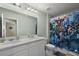 Bright bathroom featuring double vanity, mirror, and shower with vibrant Marvel superhero themed curtain at 2455 Hastings Blvd, Clermont, FL 34711