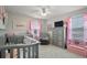 Charming bedroom with a crib, rocker, and decorative pink accents and a 