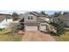 Two-story home with a large driveway, brick accents, and a well-manicured lawn at 2455 Hastings Blvd, Clermont, FL 34711