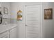 Hallway with white cabinetry, tile backsplash, decorative signs, and a door at 2455 Hastings Blvd, Clermont, FL 34711