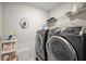 Laundry room with modern washer and dryer, shelving, and cleaning supplies at 2455 Hastings Blvd, Clermont, FL 34711