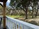 View of spacious backyard with mature trees from covered back porch at 2685 Cr 776, Webster, FL 33597