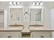 Bathroom featuring a double vanity with granite countertops, framed mirrors, and modern lighting at 2685 Cr 776, Webster, FL 33597