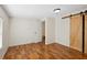 Bedroom features wood-look laminate flooring and a decorative sliding barn door at 2685 Cr 776, Webster, FL 33597