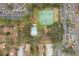 Aerial view of a condo complex features tennis courts, pool, mature trees, and ample parking spaces at 2804 N Powers Dr # 27, Orlando, FL 32818